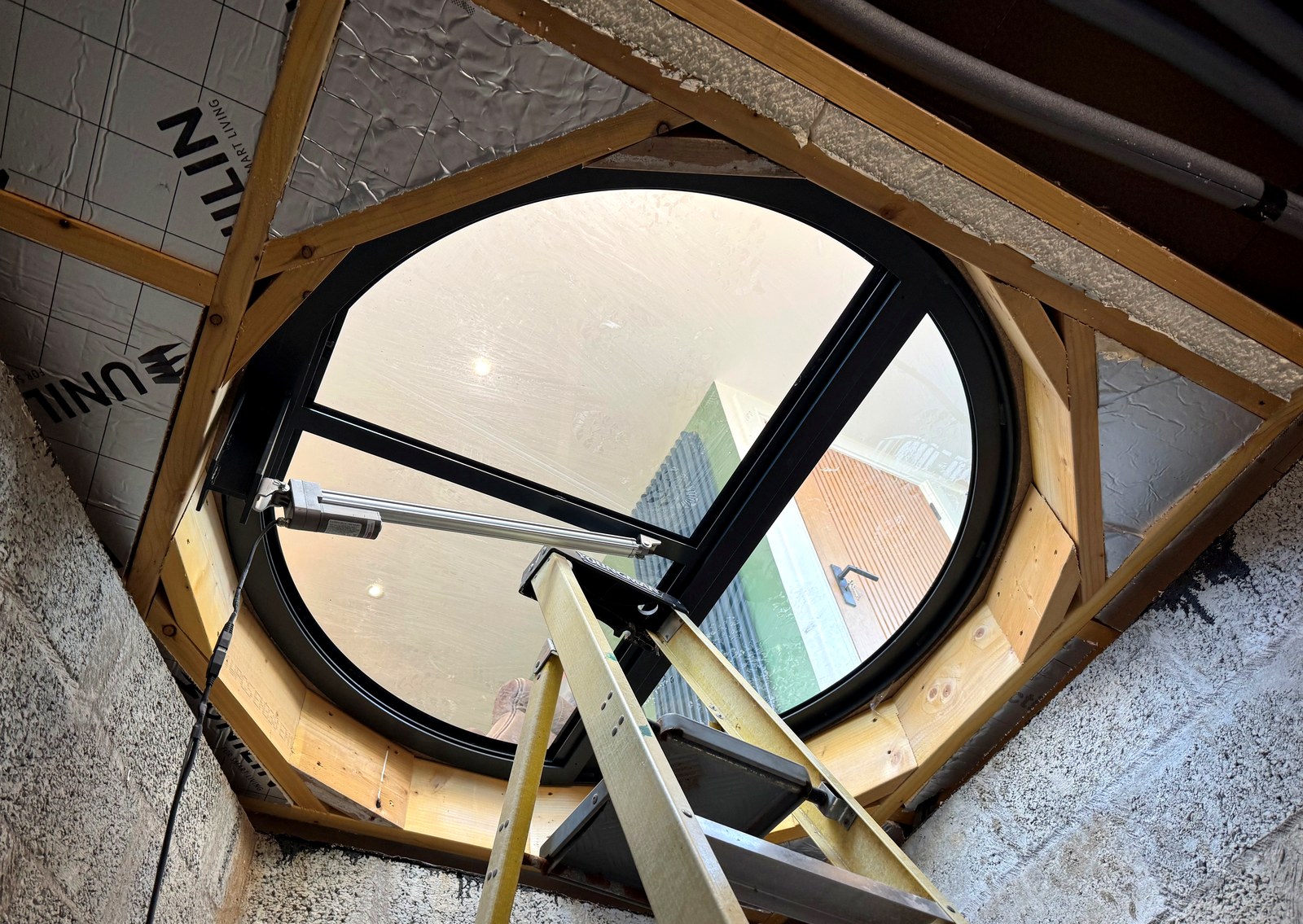 Circular electric glass wine cellar door installed and open, seen from below in a new cellar, Scotland